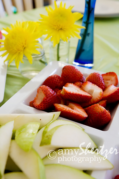 yellow flowers add even more color to a plate of pears and strawberries
