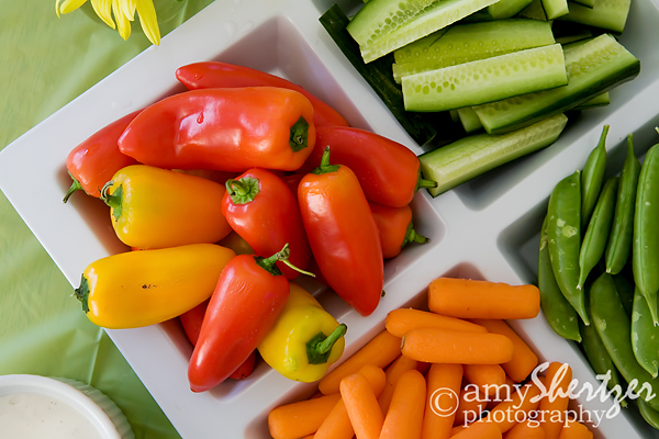 Mini bell peppers, carrots, cucumbers, and sugar snap peas adorn a colorful veggie tray