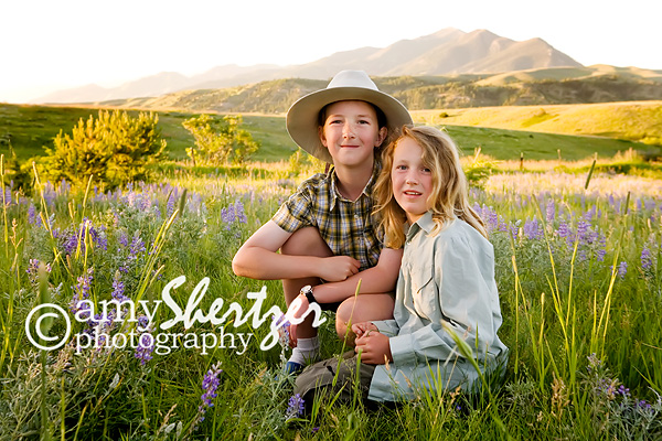 Brothers pose in a sunset field in front of the Bridger Mountains