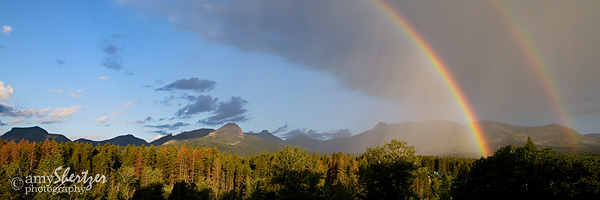 A double rainbow bends over the mountains of Glacier National Park