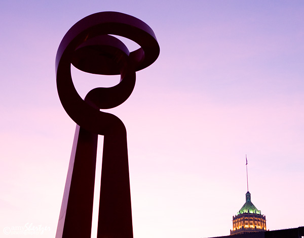 A graphic sculpture in San Antonio is silhouetted in front a beautiful purple dusk.
