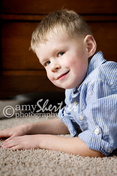 A handsome boy gives a sly smile during a portrait session