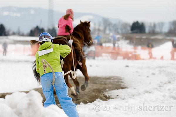 A girl lands a ski jump in a skijoring event.