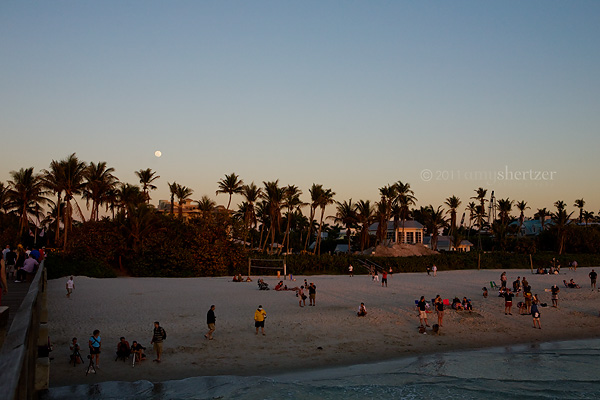 The full moon rises over the Naples Beach
