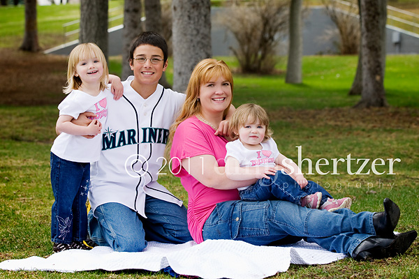 A beautiful mom poses with her children in the park.