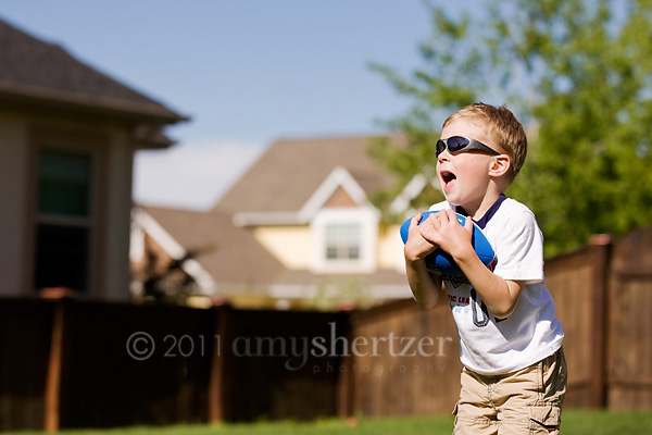 A boy plays catch in his backyard on a sunny summer day in Bozeman, Montana.
