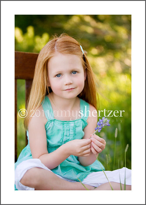 A red-headed preschool girl poses for a portrait.