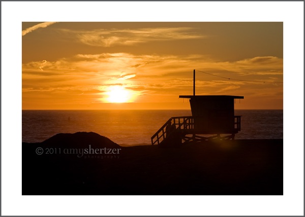 A lifeguard stand on a Los Angeles beach at sunset.